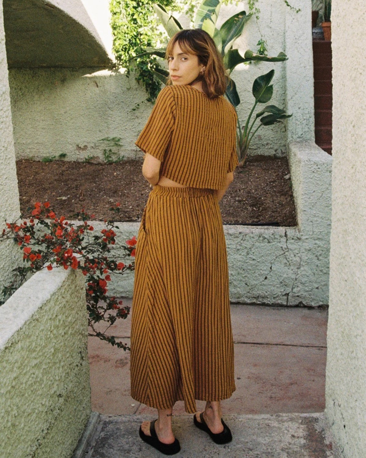 Curator Fawn avocado green stripe skirt at Clad, a sustainable clothing boutique in Asheville, NC. Paired with the matching Hanna top and black flats.