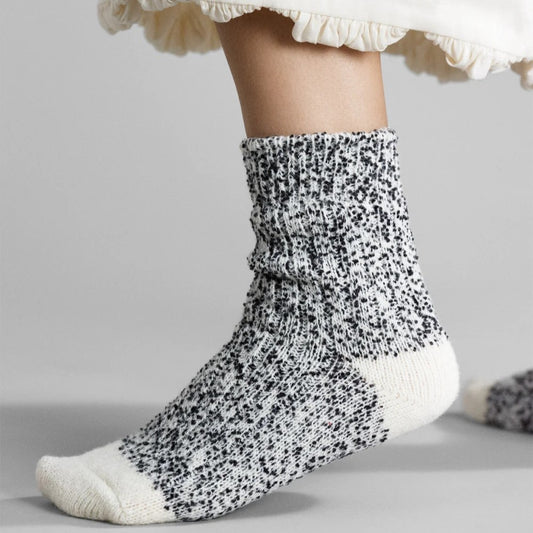 Multicolor wool blend socks with black and white speckles at Clad, a sustainable clothing shop in Asheville, North Carolina. Made by Hansel from Basel.