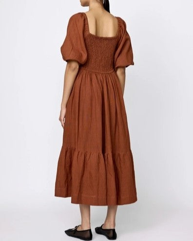 Amber smocked midi linen cotton dress by LAUDE the Label. Puff sleeves, square neckline, and bottom tier. Paired with black flats.