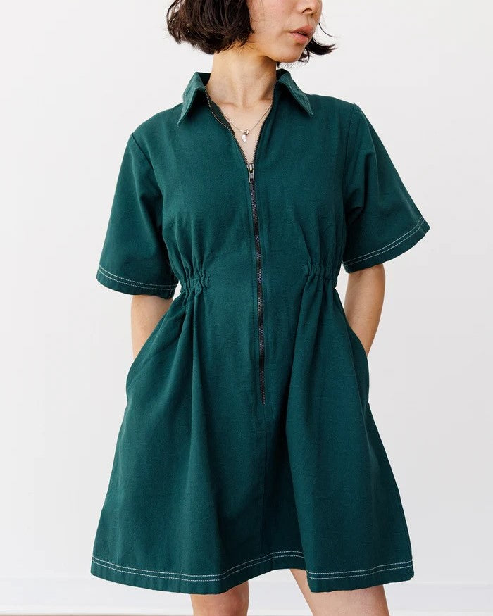 Noble utiliy dress in hunter green with white contrast stitching