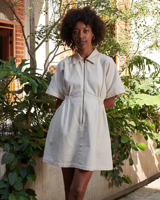 Utility dress from Noble in oat milk with a peter pan collar and cinched waist with zipper down the front at Clad, a sustainable clothing boutique in Asheville, NC