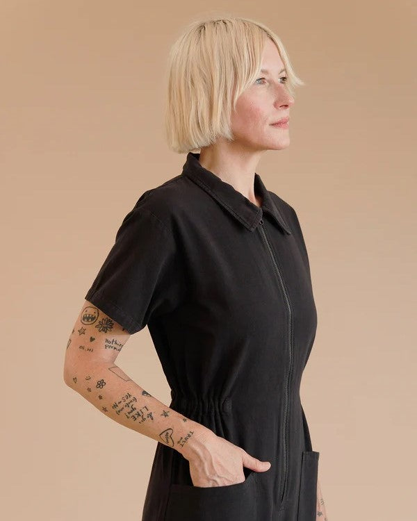 Black zip-up utility jumpsuit short sleeves with collar, cinched waist, and cropped ankle straight leg at Clad, a sustainable clothing shop boutique in Asheville, NC.