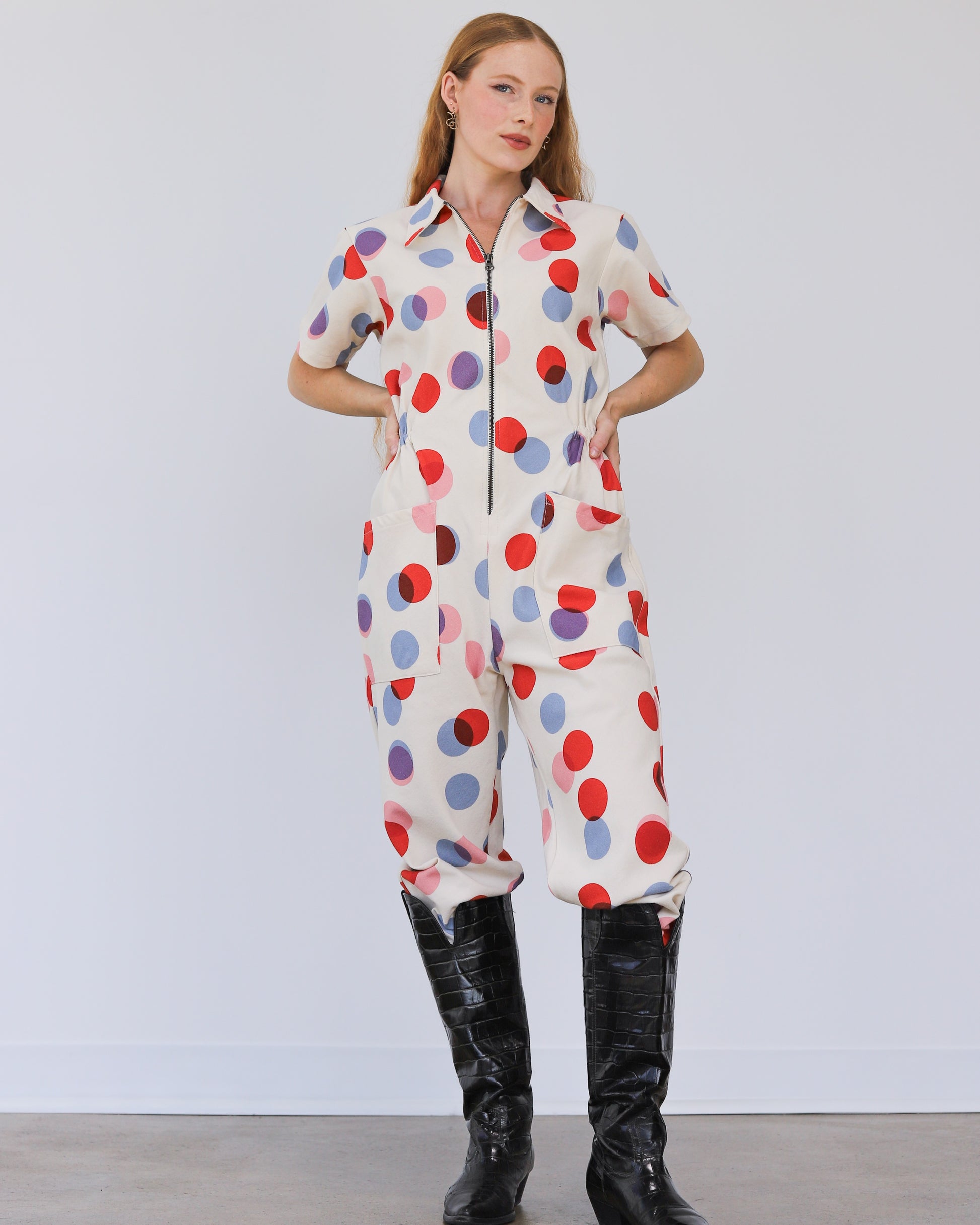 Noble utility suit jumpsuit in polka dot with zipper down the front and paired with black leather boots at Clad, a sustainable clothing store in Asheville, NC