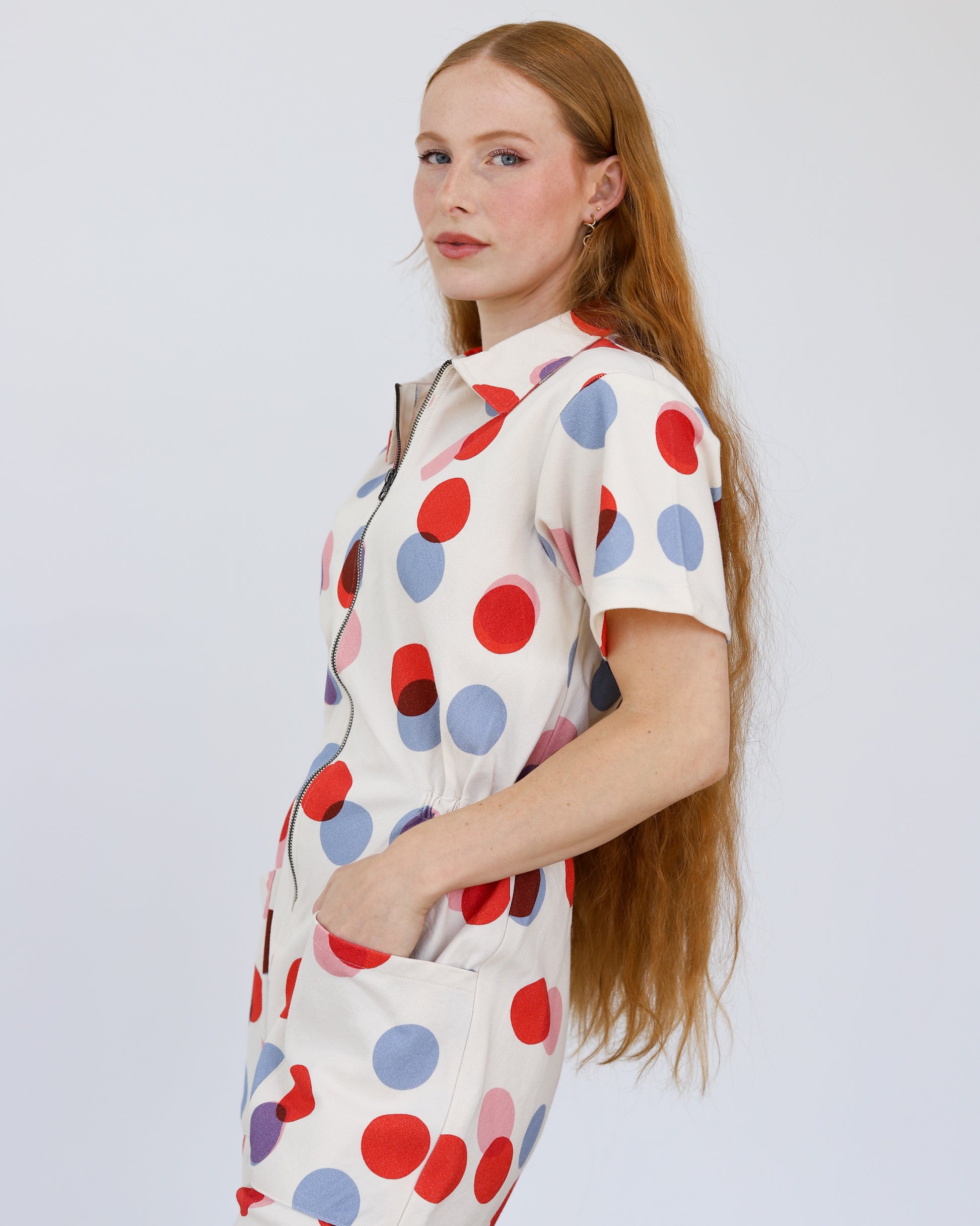 Noble utility suit jumpsuit in polka dot with zipper down the front and paired with black leather boots at Clad, a sustainable clothing store in Asheville, NC