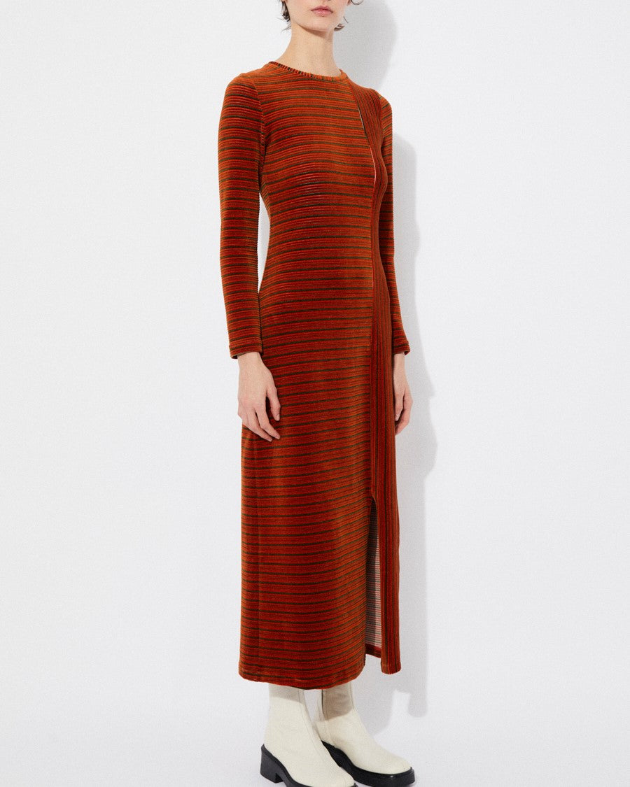 Long-sleeve velvet knit burnt orange rust Corba dres by Rita Row in Spain. Stripes and linework with a midi length and front slit. Paired with chunky white boots.