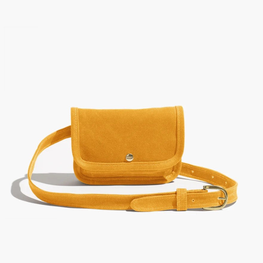 Belt bag by Small Lot Co in aprict gold mustard yellow with a metal snap, adjustable waist. Fanny pack style made from cotton canvas.