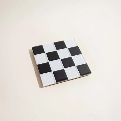 Glass tile coaster by Subtler Art Co in black and white checkers at Clad, a sustainable clothing boutique in Asheville, NC.