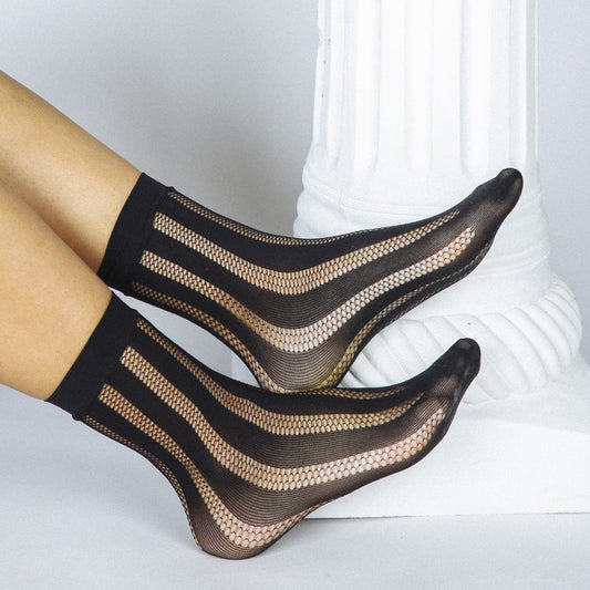 A sheer fishnet black striped sock that pairs perfectly with heels, boots, clogs, and more.