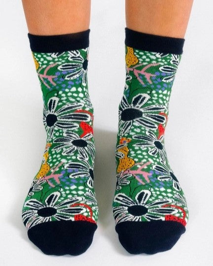 A forest green ankle sock with flowers and cats.