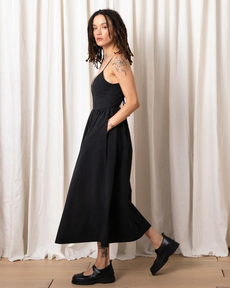 Black tie back midi dress by Ali Golden with a fitted v-neck bodice, adjustable spaghetti straps, and fully lined. Paired with chunky black loafers.