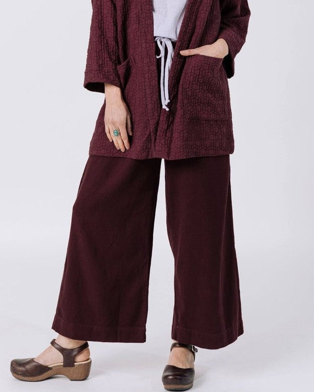 Curator atlas pant in burgundy paired with clogs and a quilted jacket