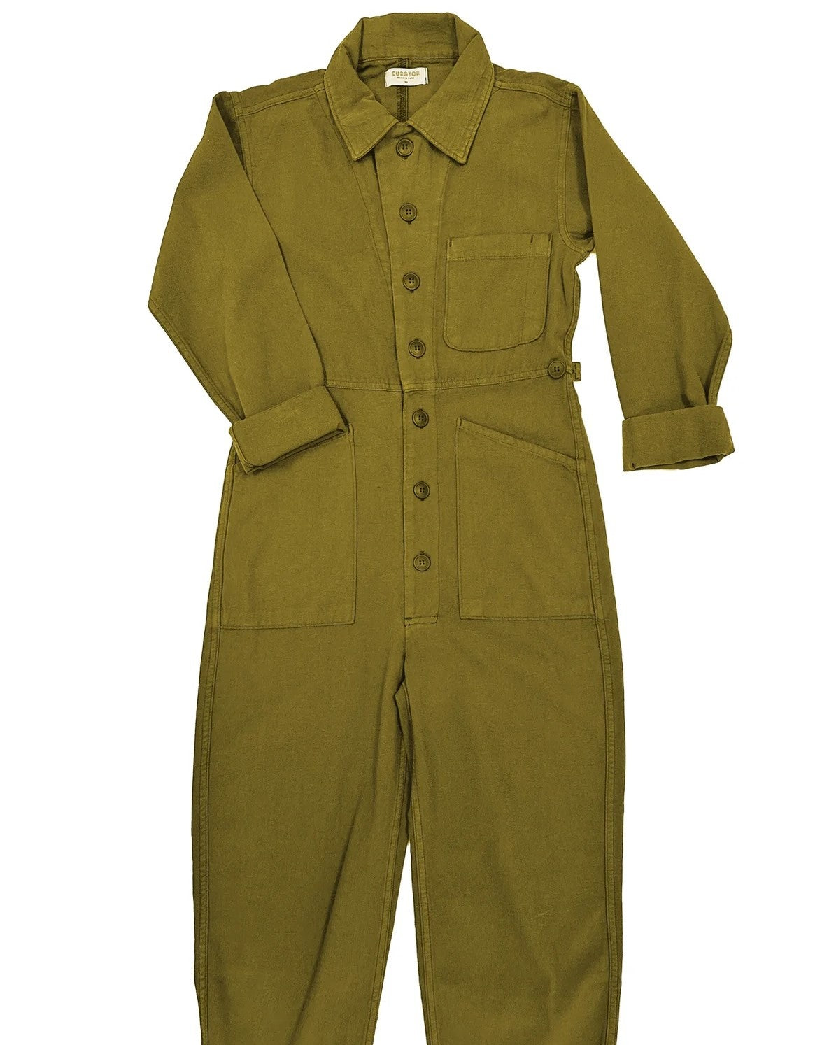 Ripley utilitarian jumpsuit in olive fennel khaki reen by Curator. Button down front, roomy pockets, and cuffed ankles and wrists.