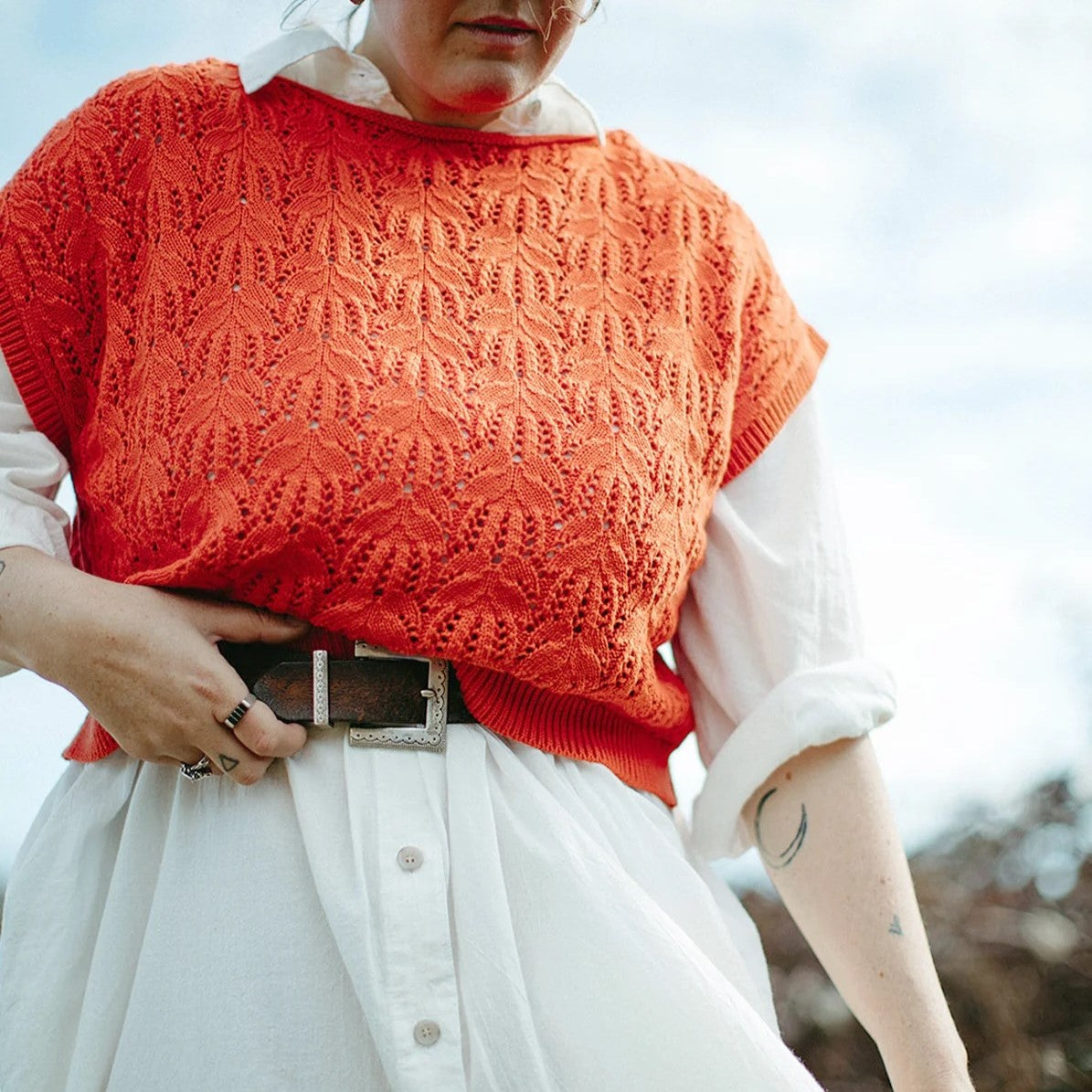 Knit tomato red sweater tank by Curator. Paired with a white button-down dress and brown leather belt.