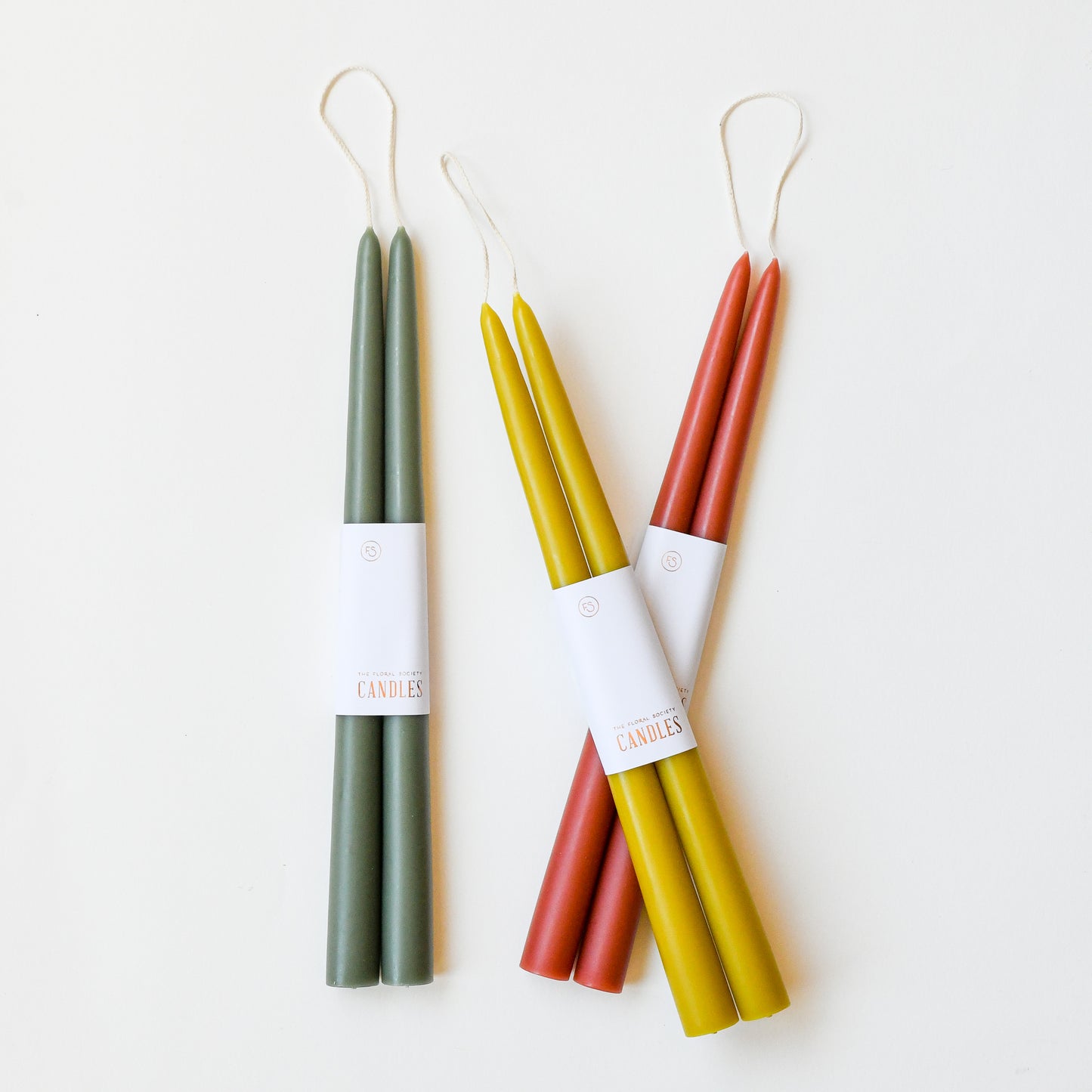 12" taper candles in a set of two in moss green, citrine chartreuse yellow, and rose clay red.