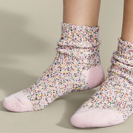 Multicolor wool blend socks with pink, yellow, blue confetti speckles at Clad, a sustainable clothing shop in Asheville, North Carolina. Made by Hansel from Basel.