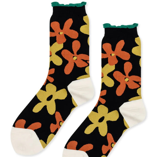 Cotton abstract floral socks in orange and yellow with a black background and bright green wavy trim. Made by Hansel from Basel.