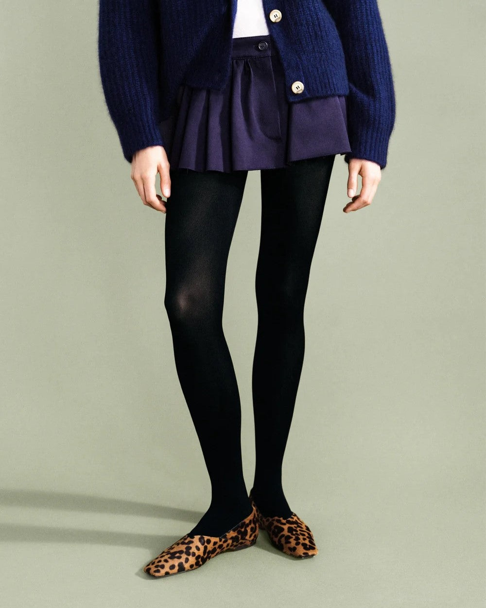 Black opaque tights by Hansel from Basel. Paired with leopard flats and a navy knit caridgan sweater and French navy mini skirt.