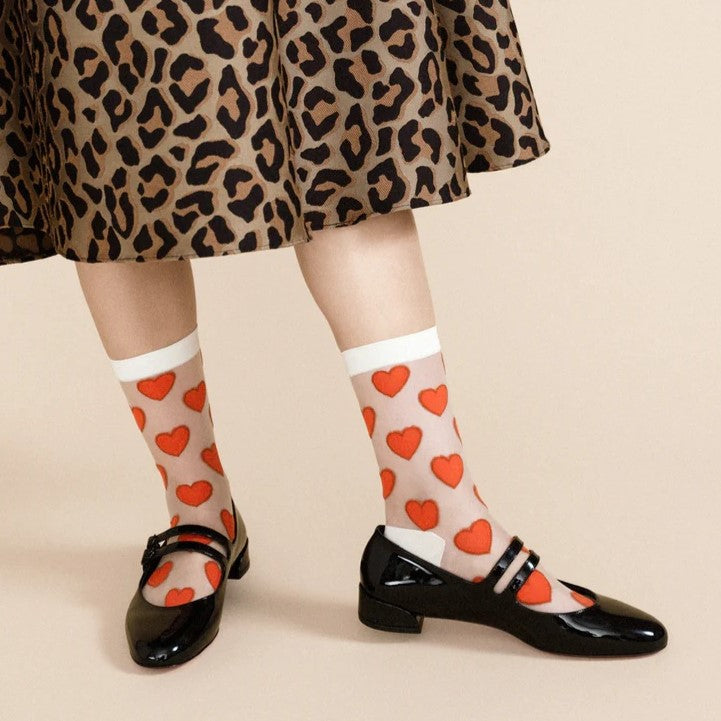 Red and white heart sheer crew sock by Hansel from Basel. Paired with a leopared print midi skirts and black shiny flats.