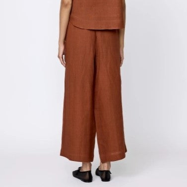 Every Pants by LAUDE the Label in an amber terracotta hue. Wide leg linen trousers with an elastic waist band. Paired with black flats.