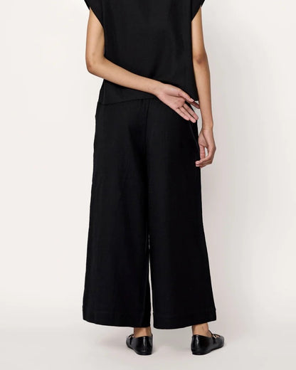 Black everyday pant by Laude the Label with elastic waistband and cropped ankle. Paired with black top and ballet flats. Find at Clad, a sustiainable clothing shop in Asheville, NC.