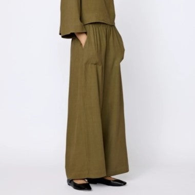 Wide leg silk Everyday Pants in olive branch green from LAUDE the Label. Elastic waistband paired with a matching top and black flats.