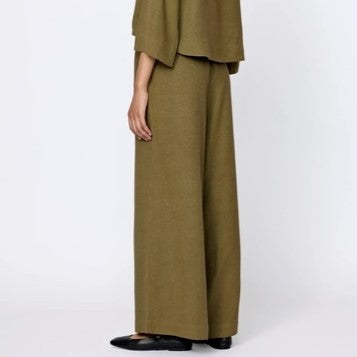 Wide leg silk Everyday Pants in olive branch green from LAUDE the Label. Elastic waistband paired with a matching top and black flats.