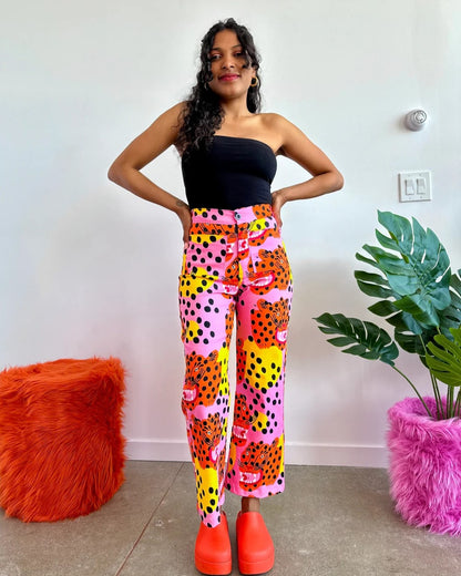 Micotti Cat orange, yellow, pink, and black polka dot bell bottom pants with a high waist. Made by Nooworks in California. Paired with chunky orange clogs and a fitted black top. 