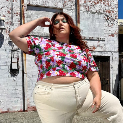 A stretchy berry printed crop top in a strawberry print. Crew neck, lilac lavender background, and yellow and white flowers. Made in California by women-owned business Nooworks.