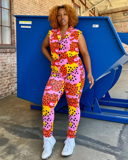 Pink, yellow, and orange tiger Micotti cat print Magic Jumpsuit by Nooworks. Button down closure front and a tapered ankle. Paired with white sneakers.