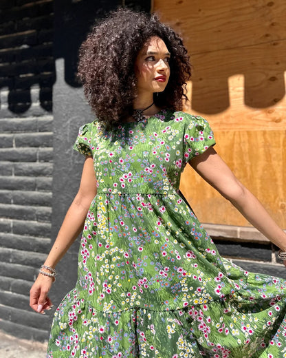 A green floral meadow dress with cap sleeves and a tiered skirt with flowers. Made in California by women-owned business Nooworks.