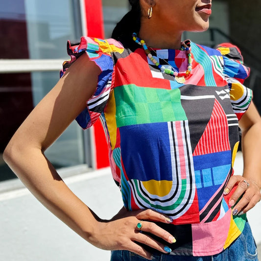 Ansley Rufle Top by Nooworks with flutter sleeve. New print with bold, abstract shapes and colors red, green, yellow, pink, blue, and black.