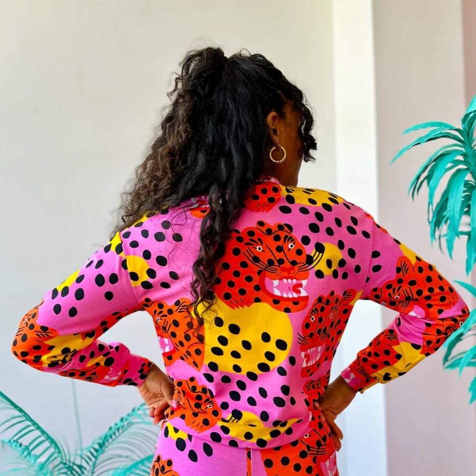 Stretchy long-sleeve track top made by Nooworks in California in Micotti Cat print. Orange, yellow, pink, and black polka dots. Paired with matching Micotti Cat Joggers and gold hoops.