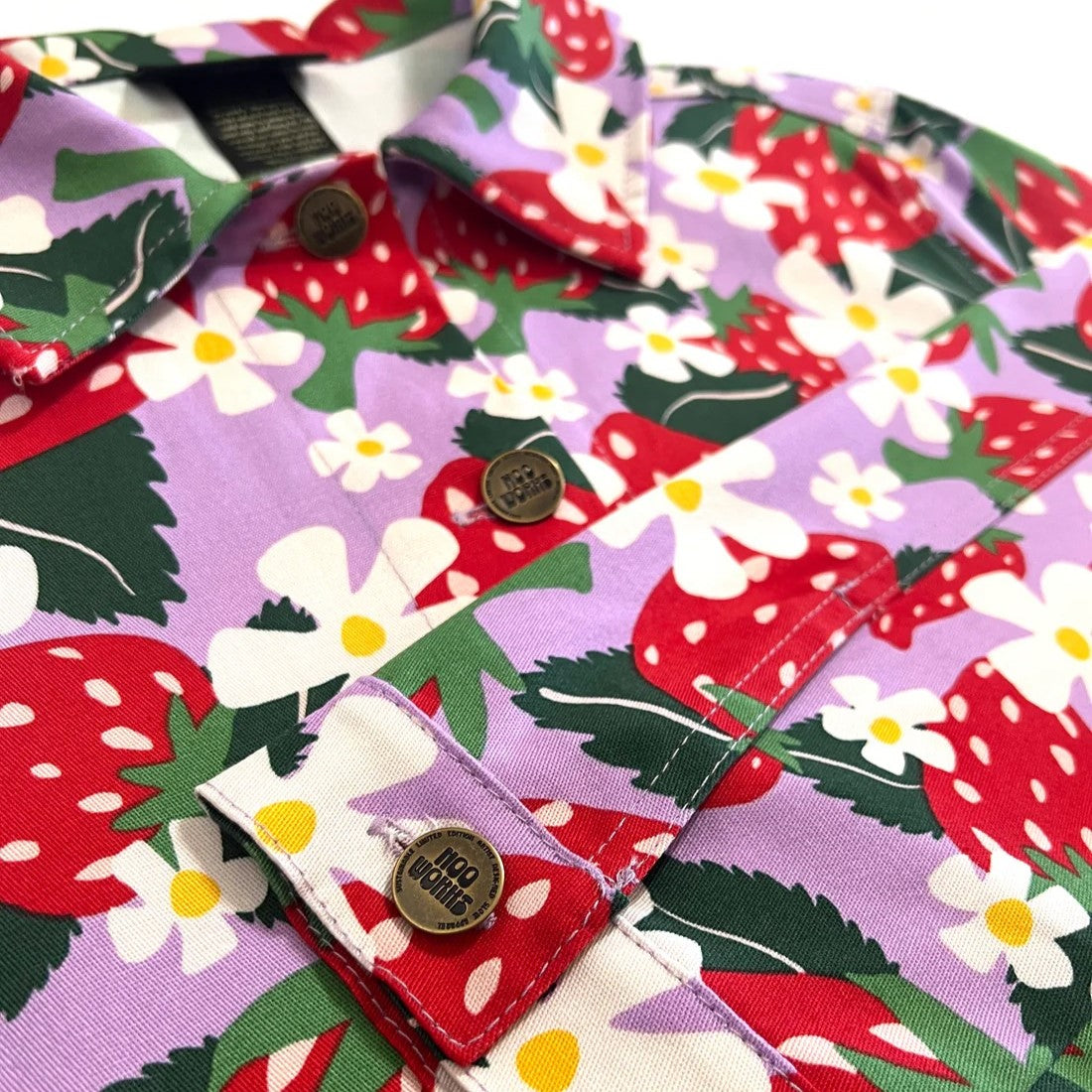 Berries Twill Shorty Jacket by Nooworks. Button-down front and collar neck. Strawberry print in red, green, lilac lavender purple with yellow and white flowers. Floral jacket.