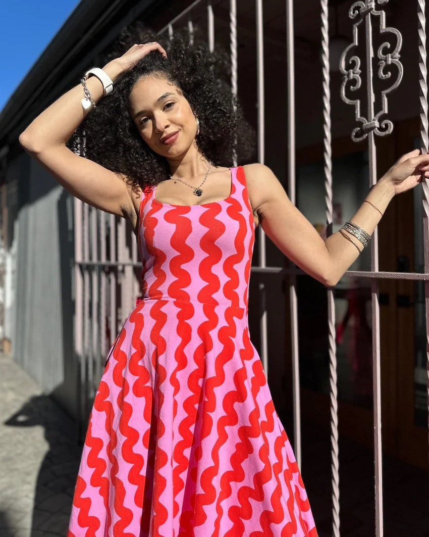 Pink Squiggle Vacation Dress by Nooworks at Clad, a sustainable clothing store in Asheville, NC. Scoop neck with thick straps and a midi skirt. 