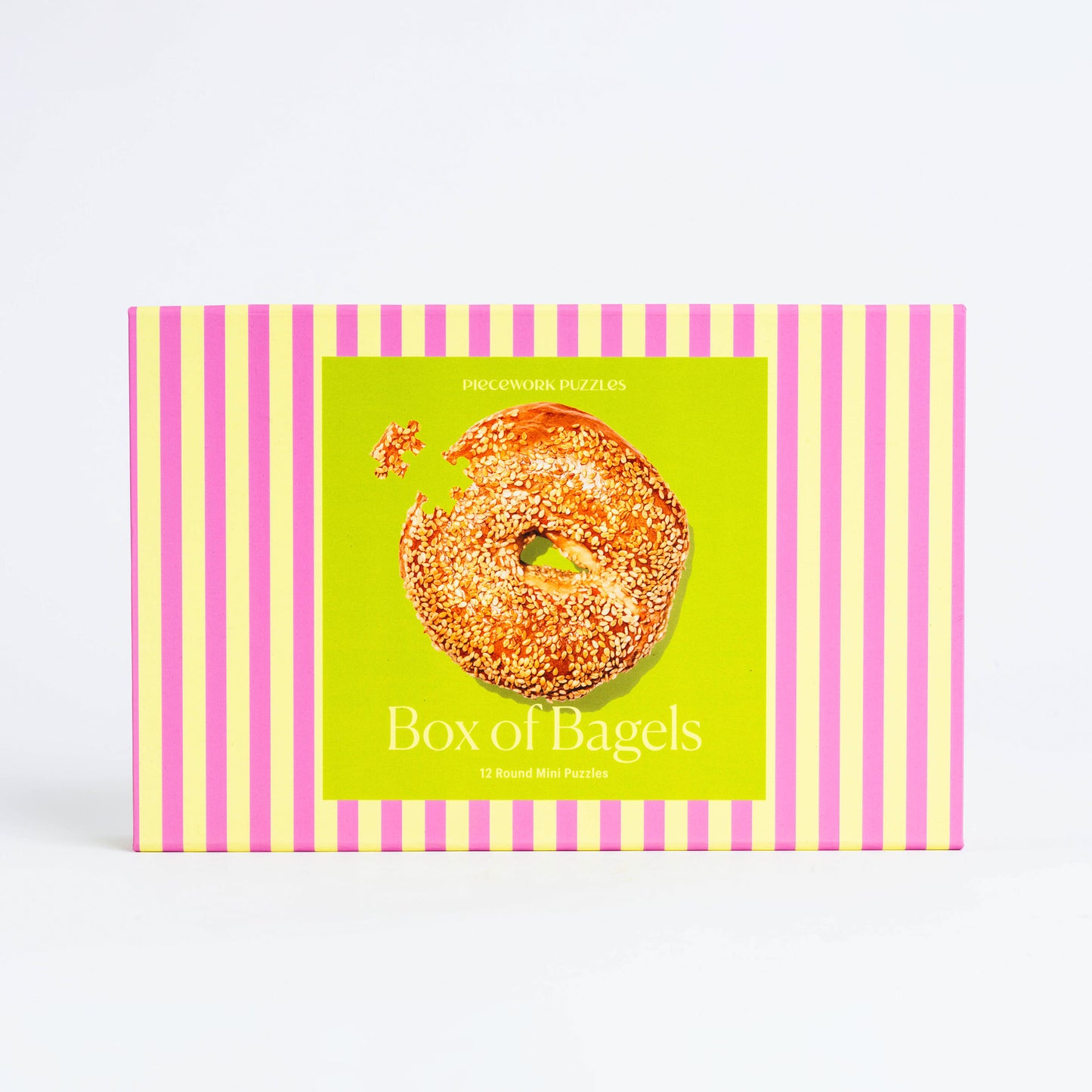 A pink and yellow striped box with 12 small 45-piece puzzles of various bagels.