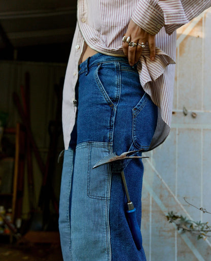 Ripton women's indigo utility jeans in Emotional Baggage, paired with a button-down striped shirt.