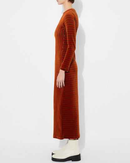 Long-sleeve velvet knit burnt orange rust Corba dres by Rita Row in Spain. Stripes and linework with a midi length and front slit. Paired with chunky white boots.