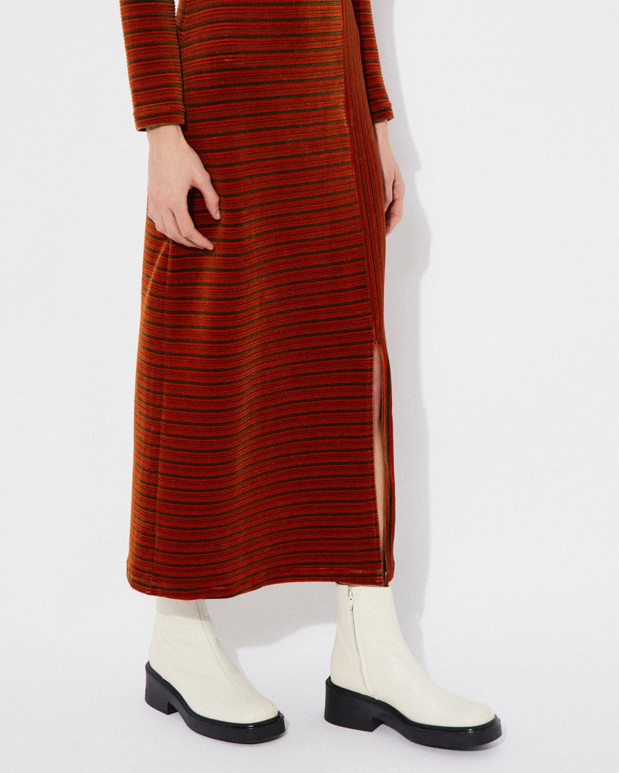 Long-sleeve velvet knit burnt orange rust Corba dres by Rita Row in Spain. Stripes and linework with a midi length and front slit. Paired with chunky white boots.