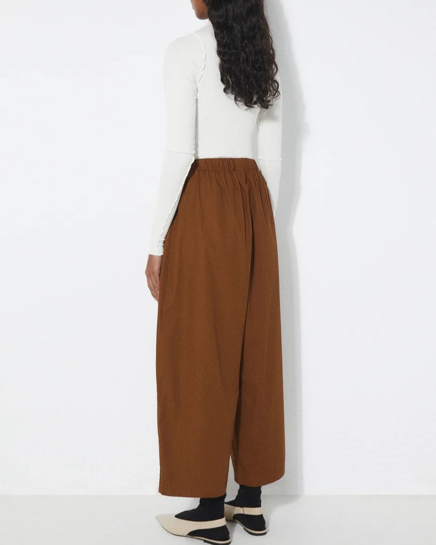 Tobacco brown Turin Pants from Rita Row at Clad, a sustainable clothing store in Asheville, NC. Paired with black socks and beige slingback flats.