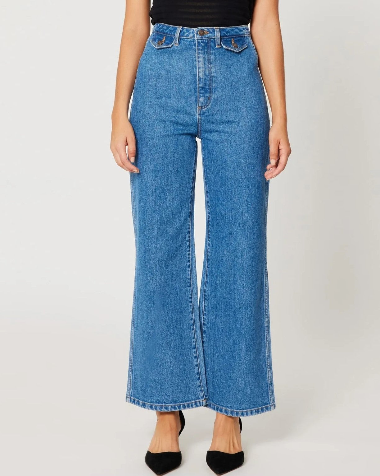 Lia medium blue sailor jeans from Rolla's, high waist with a wider cropped ankle leg. Paired with black pumps and a see-through top.