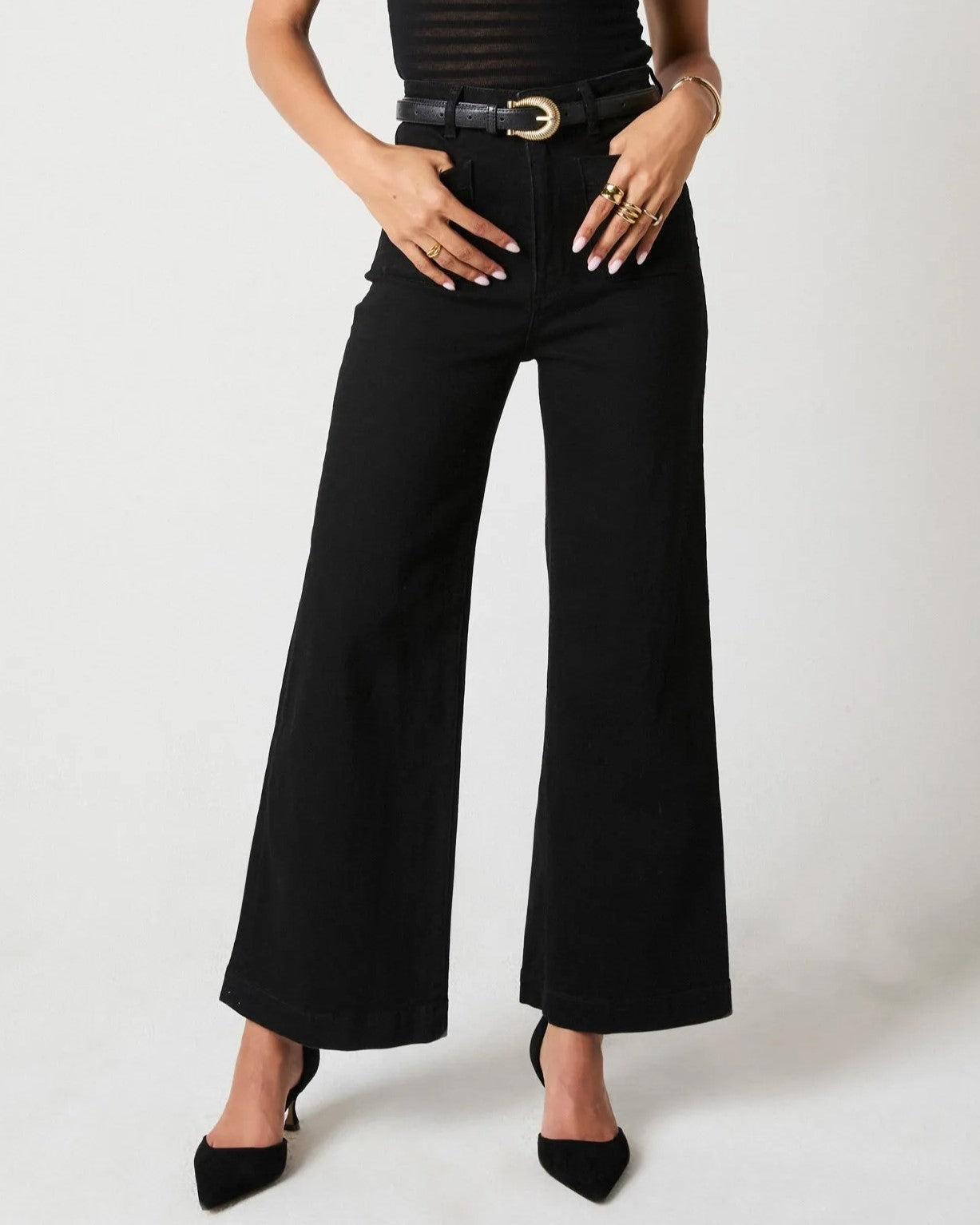 Rinse black sailor jeans from Rolla's, high waist with a wider cropped ankle leg. Paired with black pumps, a see-through top, and a statement belt.