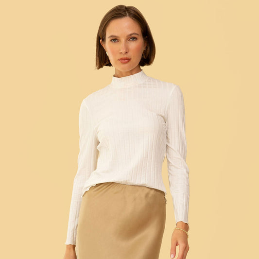 Mock neck long sleeve fitted Gigi Top by Whimsy & Row in cream. Paired with a beige silk skirt.