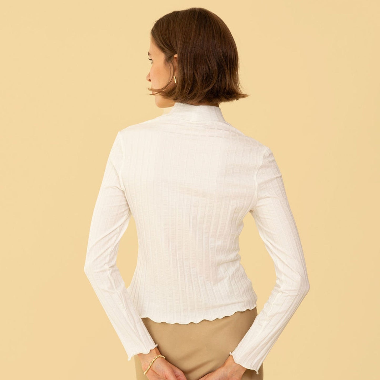 Mock neck long sleeve fitted Gigi Top by Whimsy & Row in cream. Paired with a beige silk skirt.